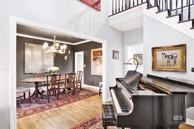 dining area with a chandelier, wood-type flooring, and ornamental molding