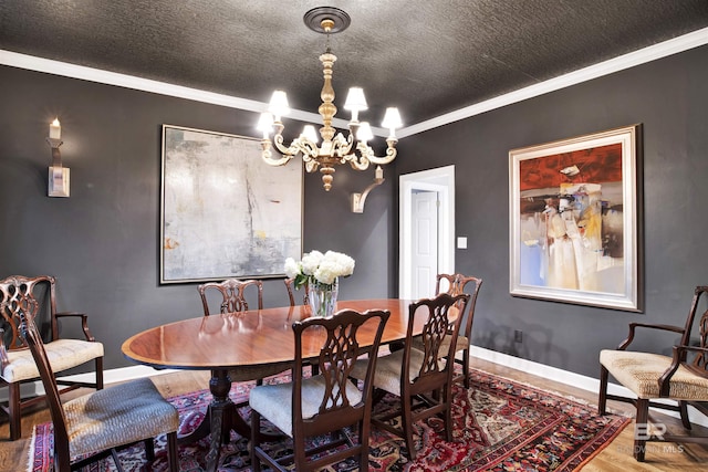 dining space featuring crown molding, a chandelier, a textured ceiling, and wood-type flooring