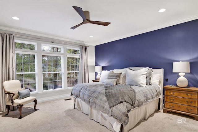 carpeted bedroom featuring ceiling fan and crown molding