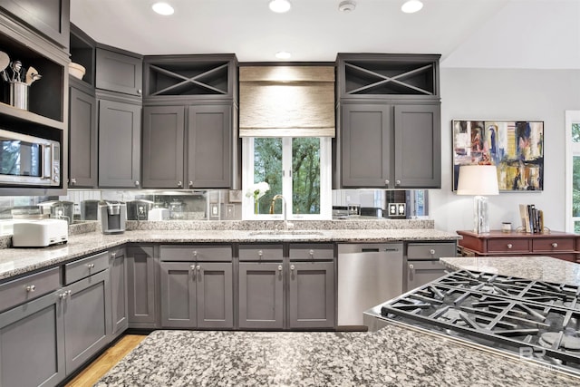 kitchen featuring light stone counters, sink, and appliances with stainless steel finishes