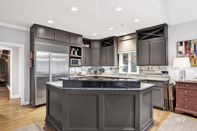 kitchen featuring a center island, crown molding, stainless steel appliances, and light hardwood / wood-style flooring