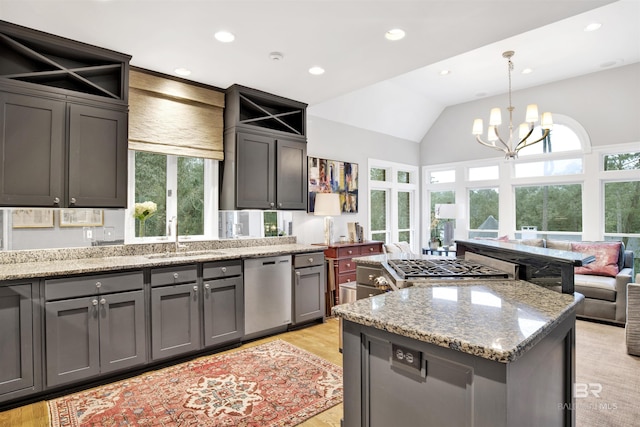 kitchen with dishwasher, sink, decorative light fixtures, a kitchen island, and a chandelier