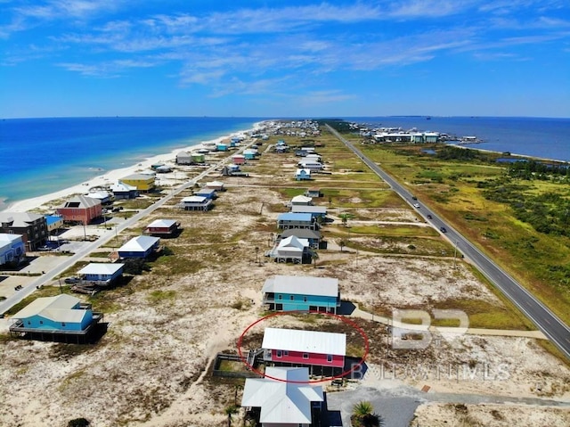 drone / aerial view with a water view and a beach view