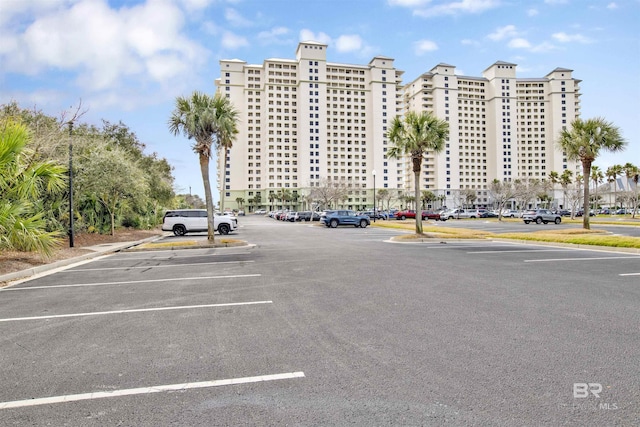 view of building exterior with uncovered parking and a city view