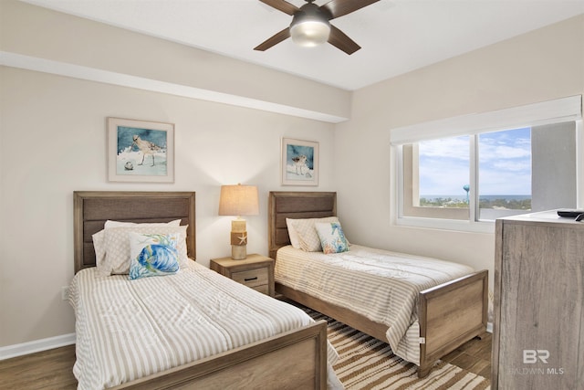 bedroom featuring ceiling fan, baseboards, and dark wood-style floors