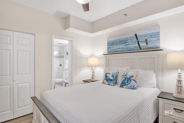 bedroom featuring light wood-style flooring, a closet, ensuite bath, a textured ceiling, and a ceiling fan