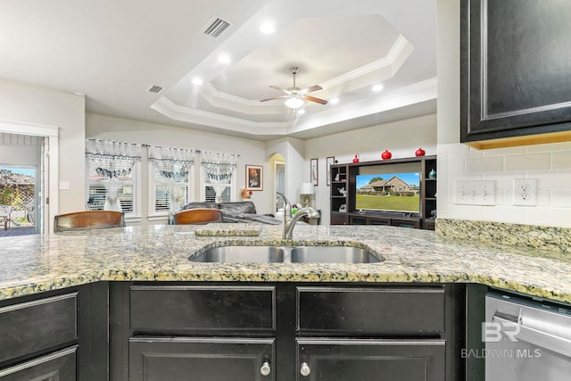 kitchen featuring tasteful backsplash, a raised ceiling, ceiling fan, and sink