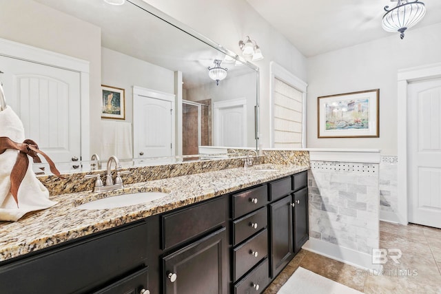 bathroom with tile patterned flooring, vanity, and walk in shower