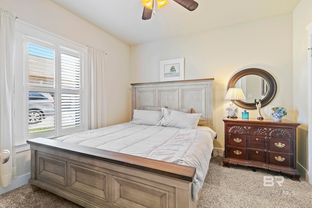 bedroom with multiple windows, ceiling fan, and light colored carpet