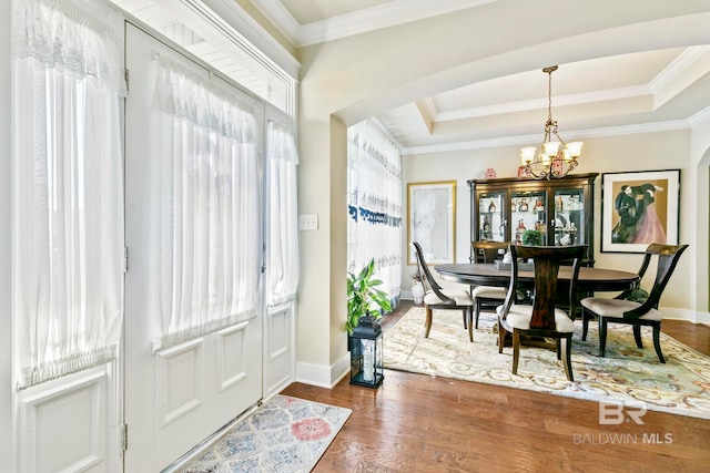 dining space featuring a notable chandelier, plenty of natural light, dark hardwood / wood-style floors, and a raised ceiling