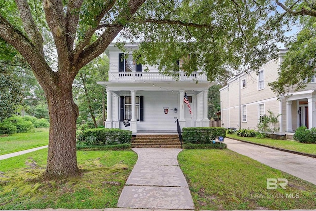 view of front of home featuring a balcony, a porch, and a front lawn
