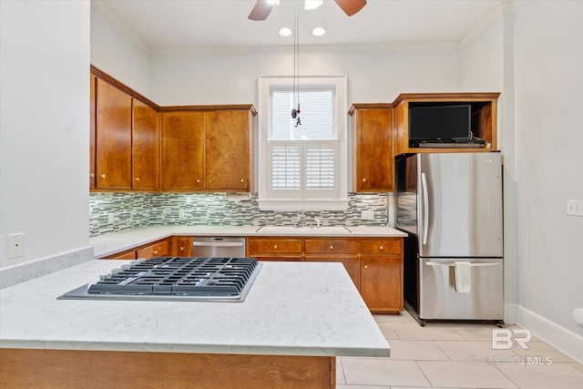 kitchen with a sink, brown cabinetry, light countertops, and appliances with stainless steel finishes