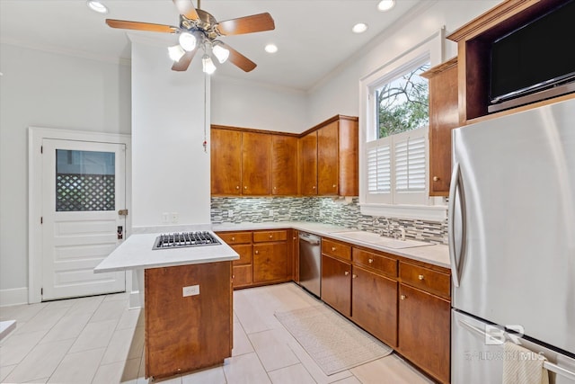 kitchen featuring a sink, crown molding, light countertops, tasteful backsplash, and appliances with stainless steel finishes