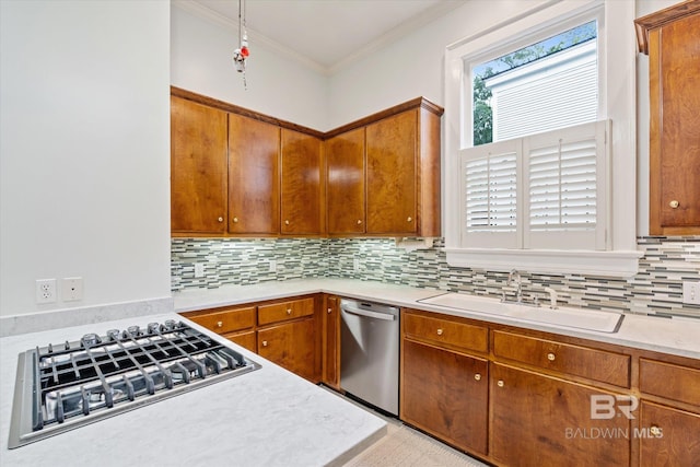 kitchen featuring a sink, decorative backsplash, brown cabinets, light countertops, and appliances with stainless steel finishes