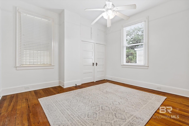 unfurnished bedroom featuring baseboards, a ceiling fan, a closet, and wood finished floors