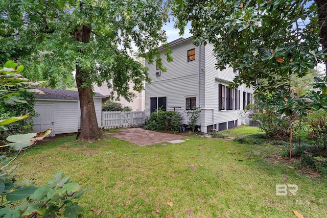 back of property with a yard, a patio, and fence
