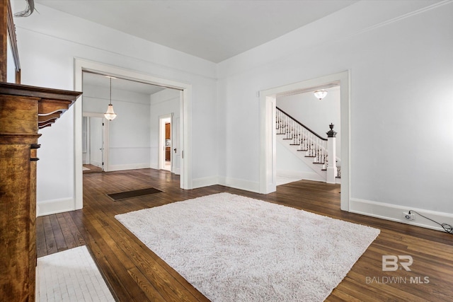 living room featuring stairway, dark wood-style flooring, and baseboards