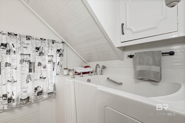 bathroom with lofted ceiling and a washtub