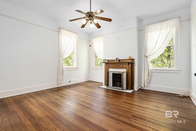 unfurnished living room featuring ceiling fan, hardwood / wood-style flooring, baseboards, and a fireplace with flush hearth