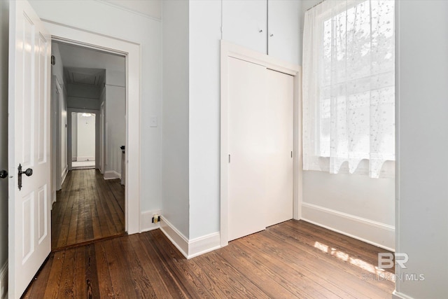 hallway with baseboards and dark wood-type flooring