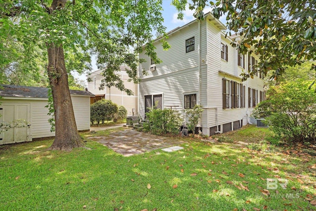 rear view of house with an outbuilding, a lawn, and a storage unit