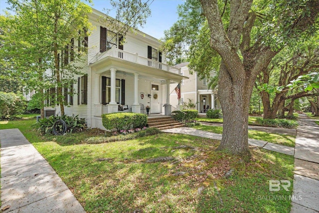 view of front of home with a porch, a front lawn, and a balcony