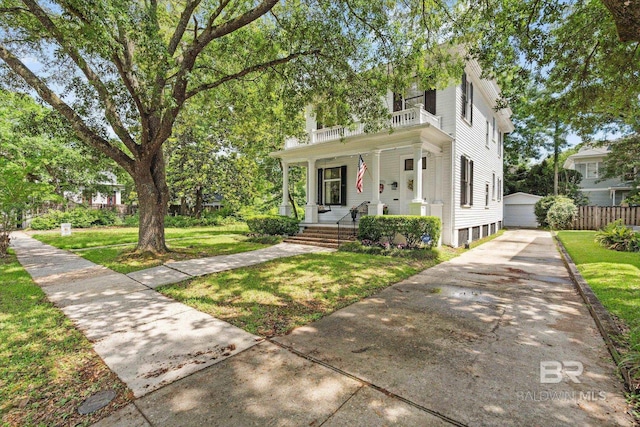 view of front of home with fence, an outdoor structure, a front yard, a balcony, and a porch
