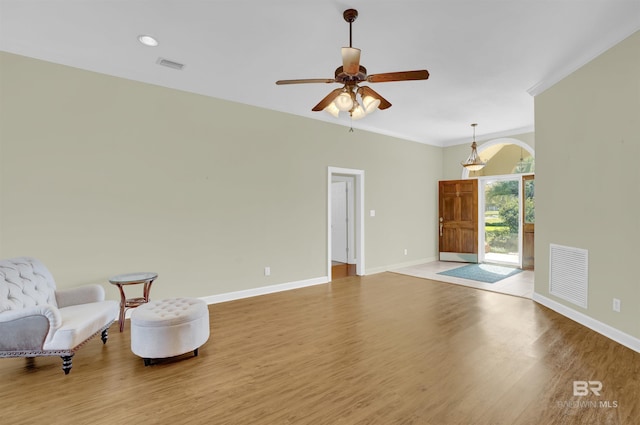 sitting room featuring wood-type flooring, ceiling fan, and ornamental molding