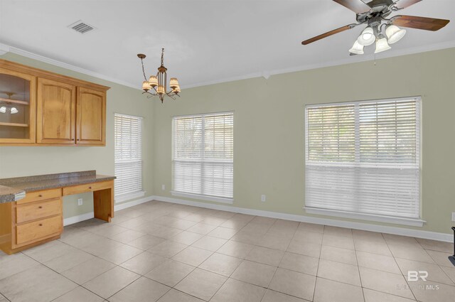 kitchen with a wealth of natural light, crown molding, light tile patterned floors, and pendant lighting