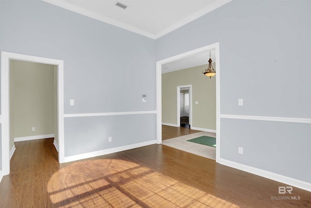 spare room with crown molding and wood-type flooring