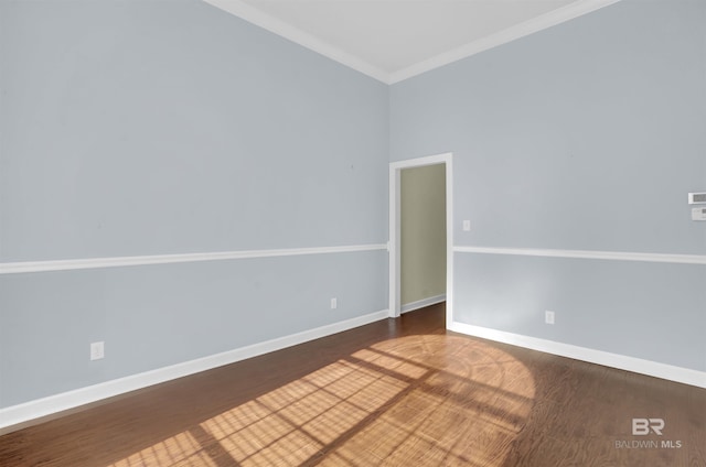 spare room featuring dark hardwood / wood-style flooring and crown molding