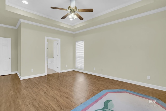 unfurnished room with hardwood / wood-style flooring, ceiling fan, crown molding, and a tray ceiling