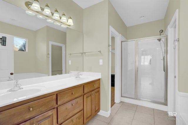 bathroom with a shower with door, vanity, and tile patterned flooring