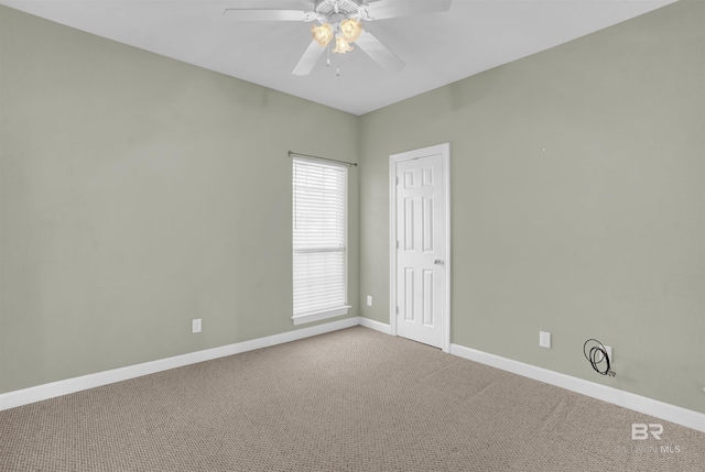 carpeted spare room featuring ceiling fan