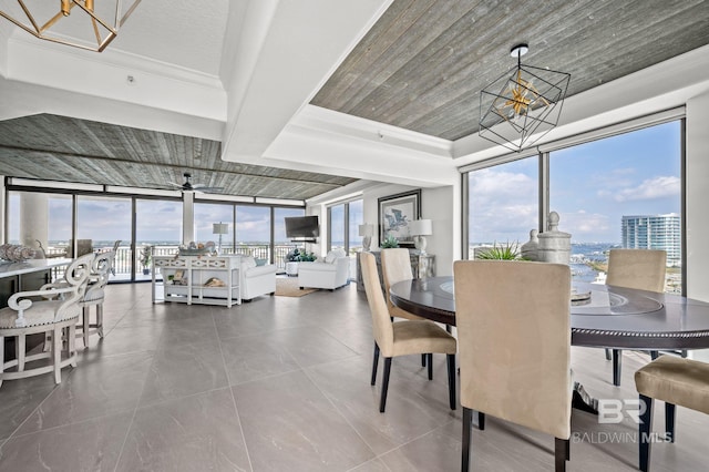 29235 Perdido Beach Blvd Unit 703, Orange Beach, AL 36561 - dining area with a chandelier, a wall of windows, a tray ceiling, and a ceiling fan