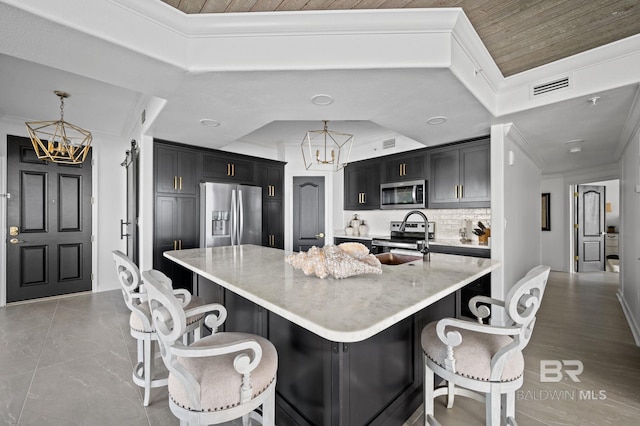 29235 Perdido Beach Blvd Unit 703, Orange Beach, AL 36561 - kitchen with a chandelier, stainless steel appliances, crown molding, decorative backsplash, and a breakfast bar