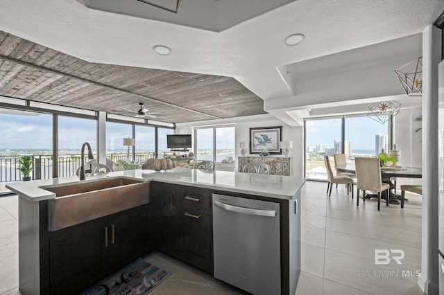 kitchen featuring ceiling fan, a wall of windows, stainless steel dishwasher, kitchen peninsula, and a textured ceiling