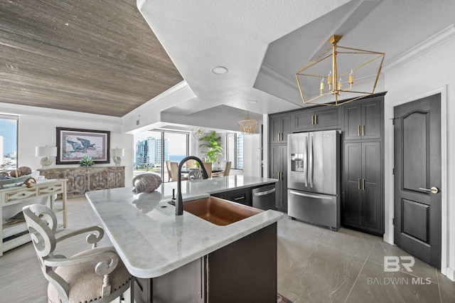 kitchen with pendant lighting, sink, light stone countertops, a large island, and stainless steel appliances