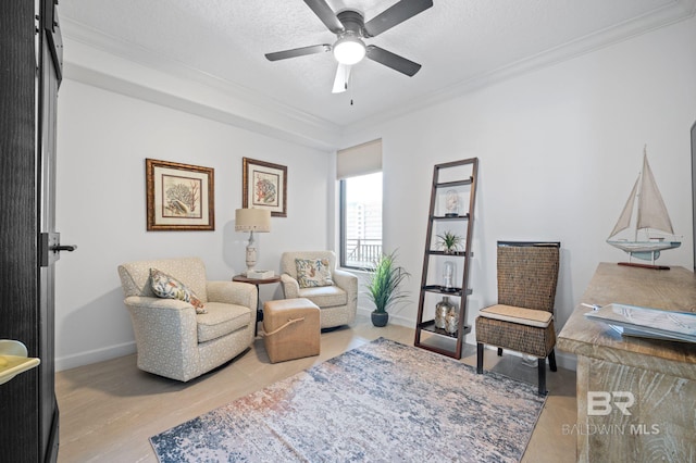 sitting room featuring ceiling fan, ornamental molding, a textured ceiling, and light hardwood / wood-style flooring