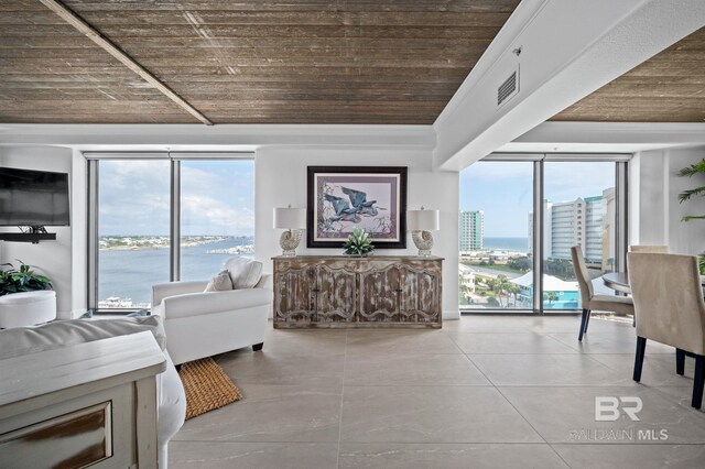 living room with plenty of natural light, a water view, wood ceiling, and light tile patterned floors