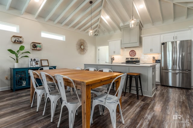 dining area with dark wood finished floors, lofted ceiling with beams, and baseboards