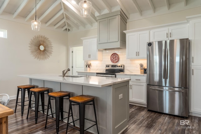 kitchen featuring beam ceiling, backsplash, appliances with stainless steel finishes, a kitchen island with sink, and a sink