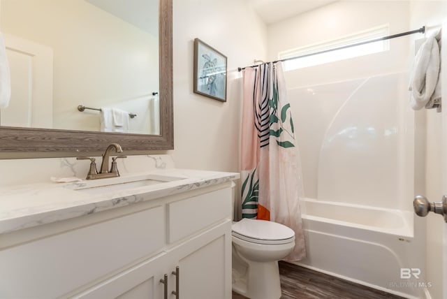 bathroom with toilet, shower / bathtub combination with curtain, wood finished floors, and vanity