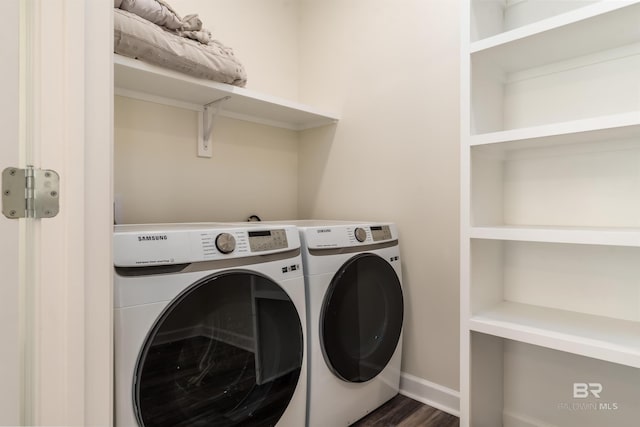 laundry area featuring laundry area, baseboards, dark wood-type flooring, and washing machine and clothes dryer