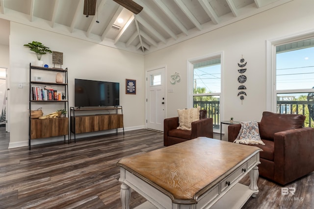 living room featuring ceiling fan, vaulted ceiling with beams, dark wood finished floors, and baseboards