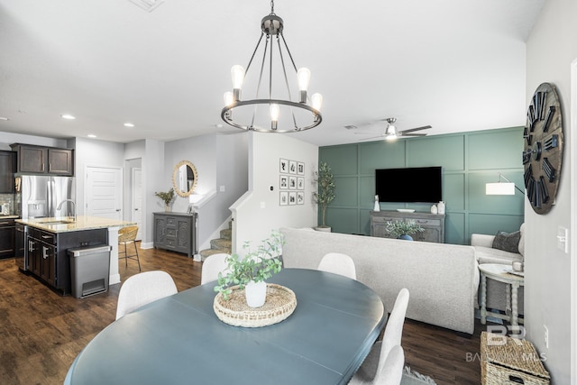dining room with recessed lighting, ceiling fan with notable chandelier, stairs, and dark wood finished floors