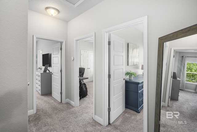 corridor with baseboards and carpet