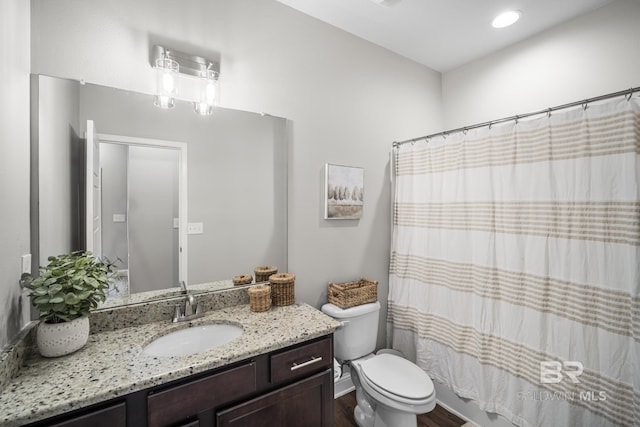 full bath with toilet, wood finished floors, and vanity