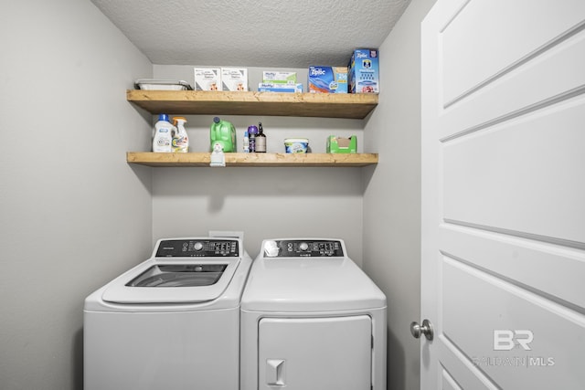 laundry room with a textured ceiling, laundry area, and washer and clothes dryer