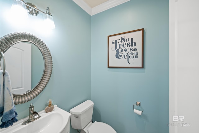 bathroom with ornamental molding, sink, and toilet